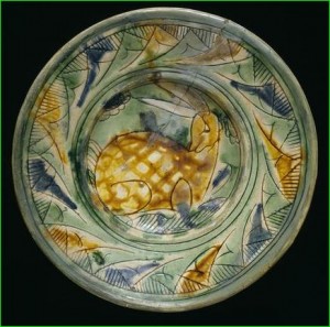 Earthenware body covered with white slip, incised decoration and painted with coloured lead glaze decoration