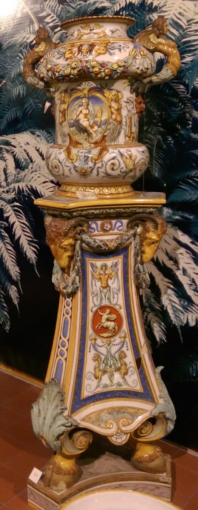 Minton & Co. flower vase and stand, circa 1851, The Potteries Museum & Art Gallery, Stoke-on-Trent. Tin-glazed earthenware, opaque whitish glaze with painted decoration. Minton named this product 'majolica'. Minton's lead-glazed product which they named 'Palissy' ware, also became known as 'majolica'.