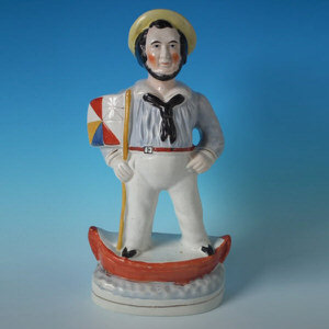 Staffordshire sailor in boat with flagsa figure