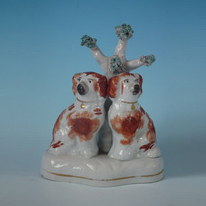 Staffordshire twin spaniels under tree figure